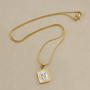 Golden snake chain necklace with a square shell pendant featuring a gold letter N
