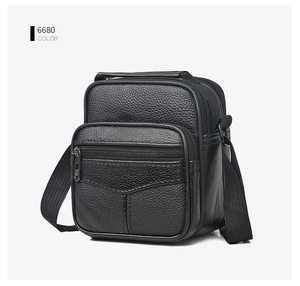 Close-up of black litchi grain leather texture and durable zippers on a multi-pocket bag