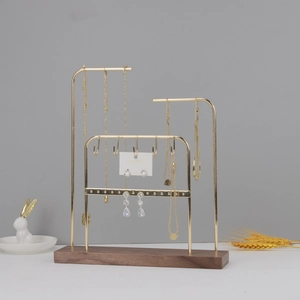 Detail showing the gold metal jewelry stand with walnut wood base and necklace hooks