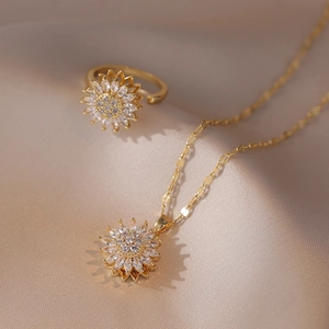Macro shot of gold sunflower jewelry set with sparkling rhinestones on champagne satin