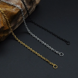 Three O-chain stainless steel necklaces in gold, silver, and black finish on wood