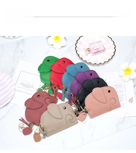 Flat lay of colorful elephant-shaped leather coin purses on a white marble background