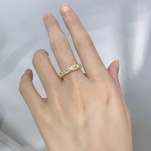 Close-up of gold plated ring with rectangular zircons worn on middle finger