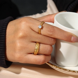 Detail of 18K gold-plated star and moon rings with zircon on model holding a cup