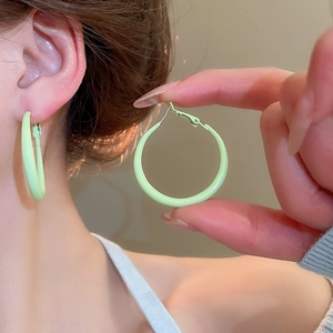 Detail of light green matte hoop earrings showing the smooth finish and secure clasp