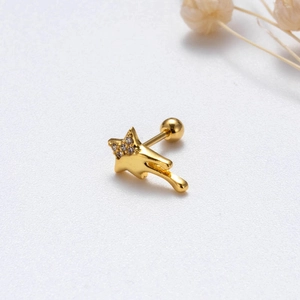 Macro shot of gold star-shaped stud earring with sparkling zircon trailing meteor tail
