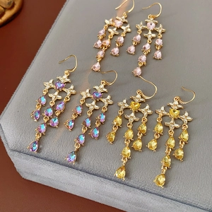 Detail of star and heart drop earrings with pink, purple, and yellow crystals