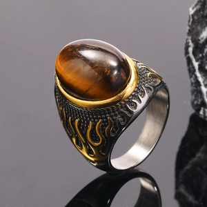 Macro view of men's punk ring with tiger eye stone and golden flame patterns