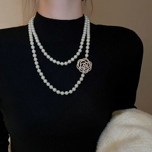 Gros plan sur un collier de perles double épaisseur avec fermoir rose diamanté