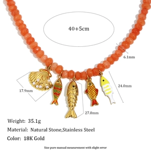 Detailed view of handmade beaded necklace with 18K gold fish and shell ocean pendants