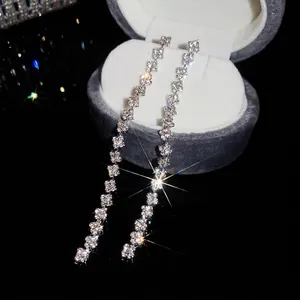 Elegant silver tassel drop earrings with sparkling square-cut zircons on a jewelry box