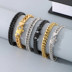 Close-up of black, gold and silver stainless steel Cuban link bracelets with lobster clasps
