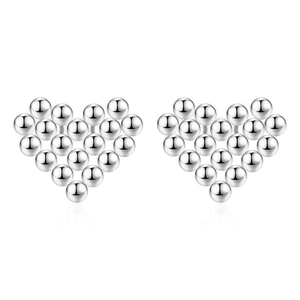 Détail de boucles d'oreilles clous en forme de cœur argenté composées de perles