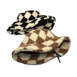 Detail of winter plaid lamb wool bucket hats in black and brown checkerboard patterns