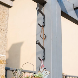 Industrial vintage black cast iron rail nail hook mounted on a vertical metal post