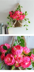 Detail of pink roses and peonies in a woven willow hanging basket with burlap bow