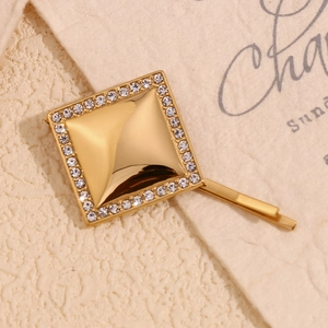 Gros plan sur la barrette carrée géométrique en or 18 carats avec accents de diamants