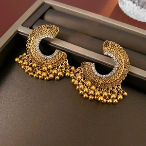 Dettaglio di orecchini Jhumka vintage dorati con strass e nappe di perline dorate
