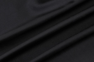 Detail of smooth black fabric texture with elegant folds and drapes of the long dress