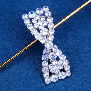 Macro detail of silver bow hair clip with sparkling pavé cubic zirconia inlay