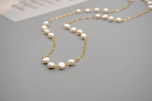 Detailed close-up of natural baroque pearls on a fine gold chain necklace for women