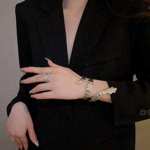 Detail of gold snake jewelry set with textured scales on spiral bracelet and ring