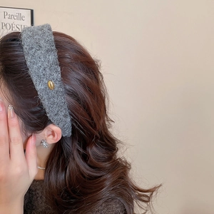Détail d'un serre-tête large floqué gris avec une plaque dorée Korea élégante