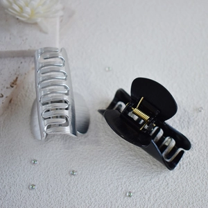 Medium metal shark hair claw clips in matte black and brushed silver with gold springs