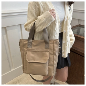 Detailed shot of khaki nylon tote bag with front pocket and adjustable shoulder strap