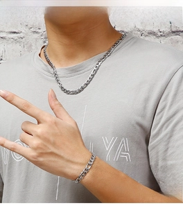 Close-up of a model wearing a heavy silver stainless steel curb chain necklace and bracelet