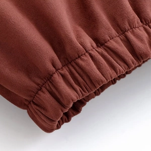 Detailed macro view of rust red faux suede jacket fabric with elastic cuff stitching