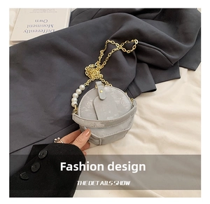 Detalle de mini bolso redondo para niña con cadena de perlas y herrajes dorados