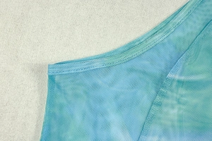 Detail of teal mesh fabric with fine net texture and double-stitched reinforced seams