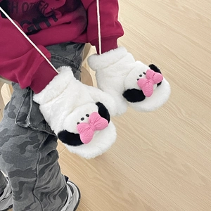 Detail of plush cartoon gloves with pink bow and soft white faux fur texture for winter