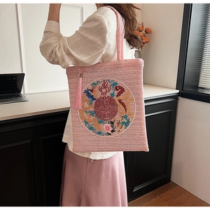 Pink woven straw tote bag featuring traditional Chinese embroidery and fringe detail