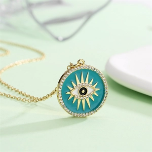 Macro detail of gold plated necklace featuring evil eye pendant with clear zircons