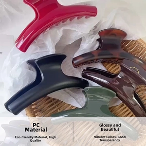 Detail view of large PC shark hair clips in gloss and matte finishes within a woven basket