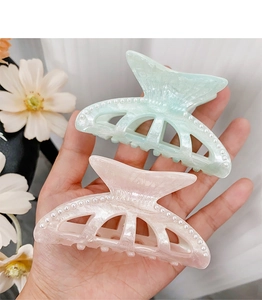 Close-up of pastel acrylic mermaid tail hair claws with white pearls and glitter finish