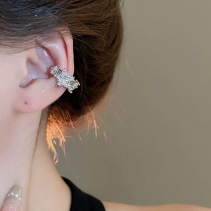 Detail of silver star ear cuff with zircon inlay on a model's ear for non-pierced ears
