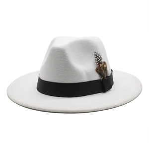 Detail of white fedora hat featuring black ribbon band and decorative spotted feather