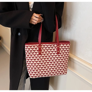 Detail of red and white heart pattern tote bag with premium leather handles