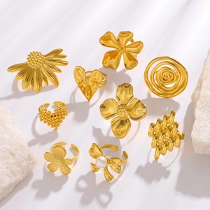 Set di anelli dorati con girasole, cuore e farfalla di perle su pietre decorative bianche