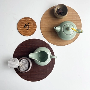 Celadon ceramic tea set with pot and cups on oval bamboo woven placemats for Kung Fu tea