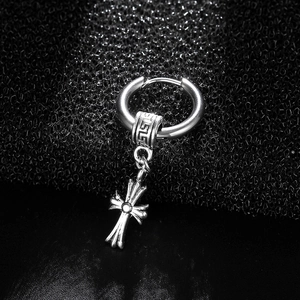 Detailed close-up of retro silver cross drop earring with Greek fret pattern engraving