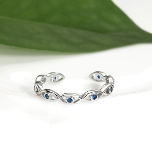 Detail of adjustable silver ring with blue zirconia evil eye pattern and open band design