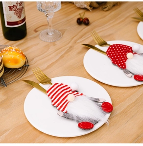 Close-up of Gnome Christmas cutlery holders with stripes and polka dots on a dining table