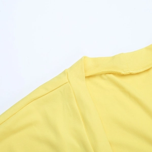 Détail du col d'un cardigan en maille jaune vif montrant la texture du tissu fin