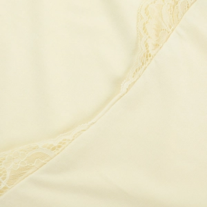 Gros plan détaillé du tissu en maille crème avec des coutures en dentelle délicate