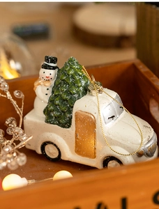 Macro view of a white vintage truck ornament with snowman and a green Christmas tree