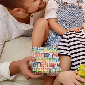 Brown kraft birthday wrapping paper with colorful typography and decorative twine